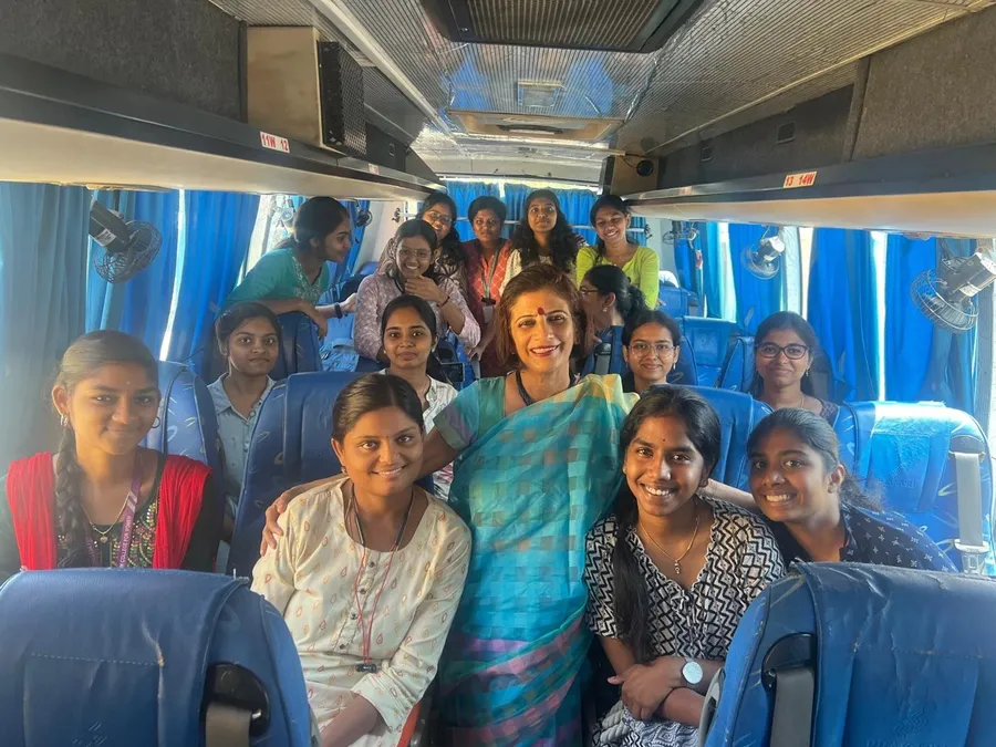 Students gathered around a PRIMAA partner on a bus during the World Autism Day outing